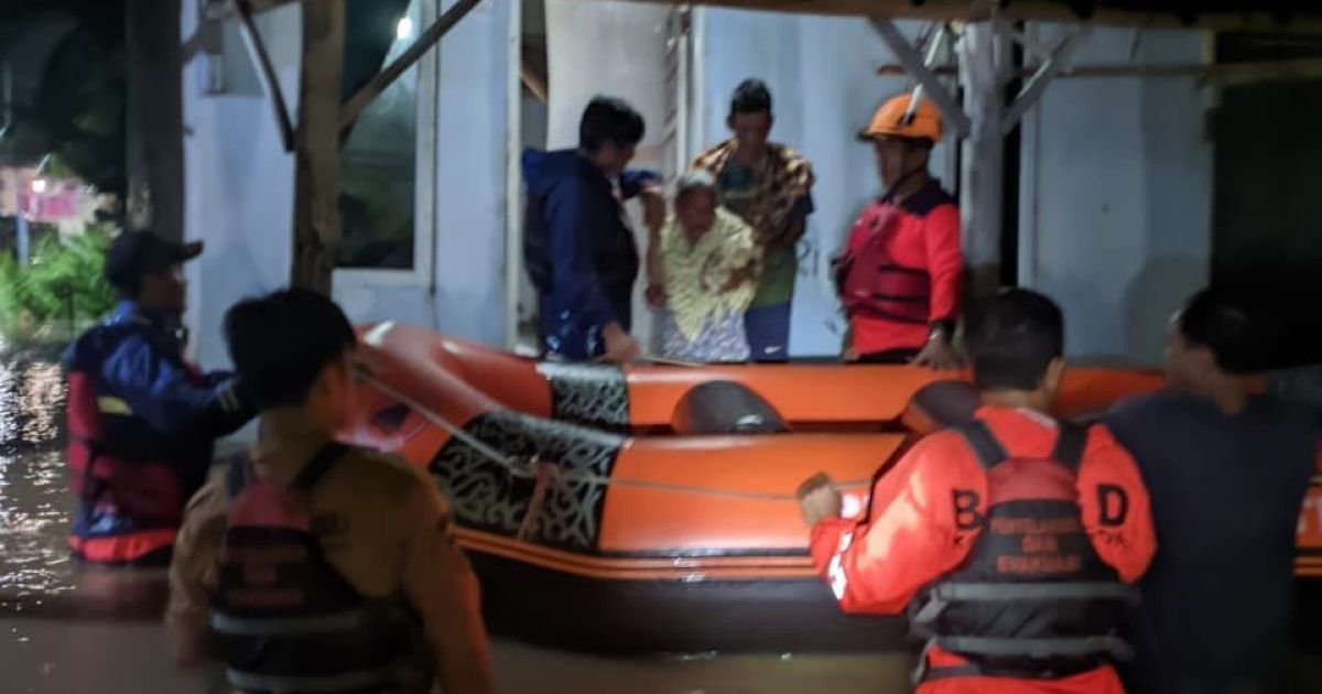 Petugas gabungan saat mengevakuasi warga yang terdampak banjir